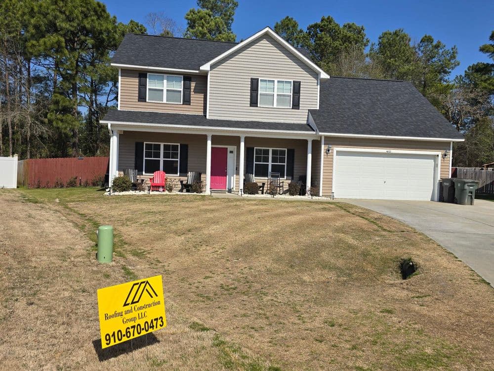 Newly built family home with landscaped yard and for sale sign in front.