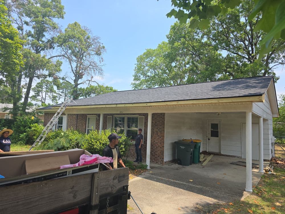 Home renovation in progress with workers installing a new roof on a suburban house.